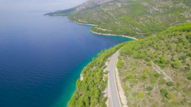 Adriyatik Denizi 'nin güzel kıyısındaki tepelerin etrafında kıvrılan manzaralı otoyol. Akdeniz 'e oyulmuş dolambaçlı panoramik yol çarpıcı derin mavi deniz ve dağınık adalar manzarasıyla.