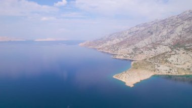 Adriyatik otoyolu ve sonbaharın ılık gölgelerinde güzel bir manzara. Sonbahar mevsiminin renklerinde çalılarla benekli mavi deniz ve kayalık arazi arasındaki şaşırtıcı manzara ve çarpıcı tezat