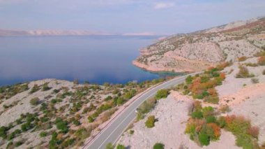 Adriyatik otoyolu güzel sonbahar kıyısı boyunca uzanıyor. Sonbahar mevsiminin canlı renk tonlarında parlayan engebeli Akdeniz manzarasının kucakladığı panoramik asfalt yol.