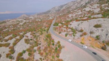 Adriyatik otoyolu güzel sonbahar kıyısı boyunca uzanıyor. Sonbahar mevsiminin canlı renk tonlarında parlayan engebeli Akdeniz manzarasının kucakladığı panoramik asfalt yol.