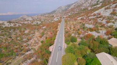 Adriyatik otoyolu güzel sonbahar kıyısı boyunca uzanıyor. Sonbahar mevsiminin canlı renk tonlarında parlayan engebeli Akdeniz manzarasının kucakladığı panoramik asfalt yol.