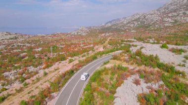 Adriyatik otoyolu güzel sonbahar kıyısı boyunca uzanıyor. Sonbahar mevsiminin canlı renk tonlarında parlayan engebeli Akdeniz manzarasının kucakladığı panoramik asfalt yol.