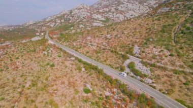 Adriyatik otoyolu güzel sonbahar kıyısı boyunca uzanıyor. Sonbahar mevsiminin canlı renk tonlarında parlayan engebeli Akdeniz manzarasının kucakladığı panoramik asfalt yol.