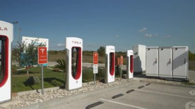 TESLA SUPERCHARGER, ZAGREB, CROATIA, 05.05.2023: Elektrikli arabalarda lityum pillerini şarj etmek için boş Tesla şarj istasyonu. Çevre dostu araçlar için erişilebilir ve verimli altyapı.