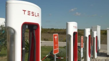 TESLA SUPERCHARGER, ZAGREB, CROATIA, 05.05.2023: Elektrikli arabalarda lityum pillerini şarj etmek için boş Tesla şarj istasyonu. Çevre dostu araçlar için erişilebilir ve verimli altyapı.