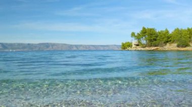 Güzel Dalmaçya kıyıları boyunca uzanan küçük dalgaların rahatlatıcı görüntüsü. İnanılmaz temiz ve berrak dalgalı Adriyatik Denizi 'nde görülebilir deniz yatağı. Yaz tatili için çarpıcı bir yer..