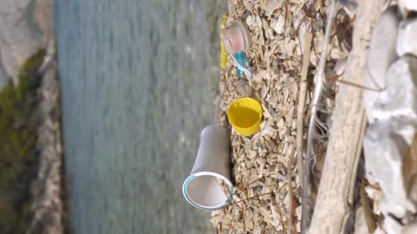 閉じる アドリア海によって洗い流された小石のビーチに散在するプラスチックごみ プラスチックごみで汚染された美しい海岸の悲しい光景 人間の不注意なさは 自然のイメージを戦利品 — ストック動画