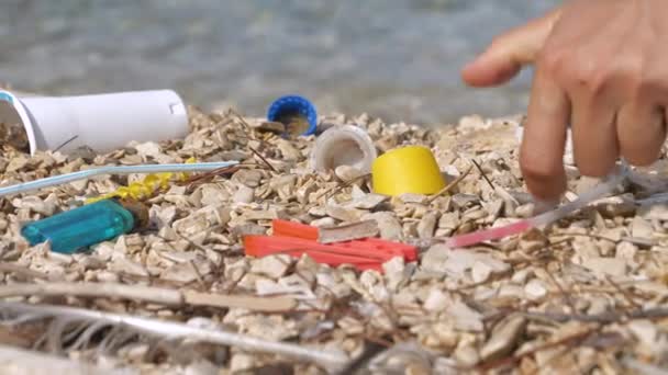 Bezárás Gondoskodó Emberi Kéz Felveszi Szétszórt Műanyag Hulladék Kavicsos Strandon — Stock videók