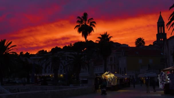 Hvar Croatia 2023年5月5日 カラフルな夕焼け空の下 Hvarの海岸沿いの町の遊歩道で穏やかな都市の喧騒 アドリア海によって歴史的な町の上の夜空に雲の壮大なカラーパレット — ストック動画