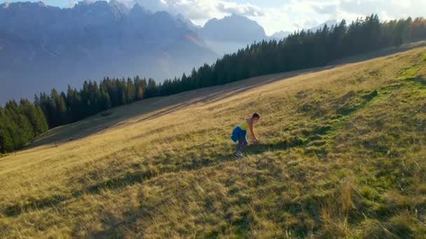 身体状况不佳的妇女挣扎着在草甸路上爬山 在一个阳光明媚的秋日 她上气不接下气 不能欣赏周围美丽的大自然和山景 — 图库视频影像