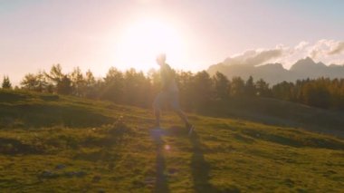 Yaklaş, LENS FlaRE: bir sabah atletik adam köpeği ile dağa koştu. Altından sonbahar güneşinin ilk ışınları Alp manzarasına yayılmaya başlarken manzaralı bir patika boyunca koşuyorlar..
