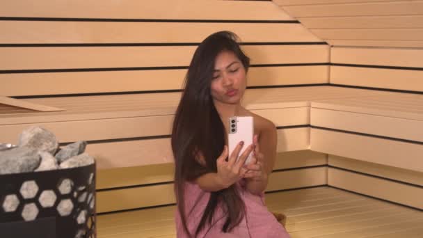 Neşeli Filipinli Ahşap Saunada Akıllı Telefonuyla Selfie Çekiyor Güzel Genç — Stok video