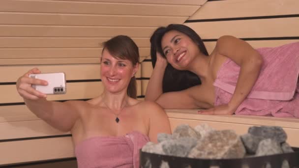 Close Fröhliche Frauen Chatten Der Heißen Finnischen Sauna Smartphone Schöne — Stockvideo