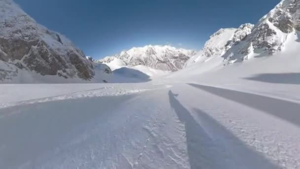 Pov 豪華なアルバニアアルプスで新鮮な粉雪に乗って楽しいスノーボード スノーボーダーは豪華な冬の風景に囲まれた手つかずの斜面を下りながら雪の雲を噴霧しています — ストック動画