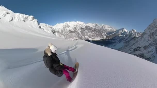 Selfie アクティブな女性は 美しいアルバニアアルプスの冒険旅行で雪山を降りながら新雪をスプレーします 彼女は雪の高い高地の間の急な手つかずのテラスを乗って楽しんでいます — ストック動画