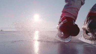 LENS FLARE, Süper Yavaş Hareketi, KAPALI: adam donmuş gölet üzerinde bir hokey duruşu yapar ve kamera önünde kayar. Siyah buz patenleriyle fren yapmaya başlayınca ezilmiş buz parçaları uçmaya başlıyor..