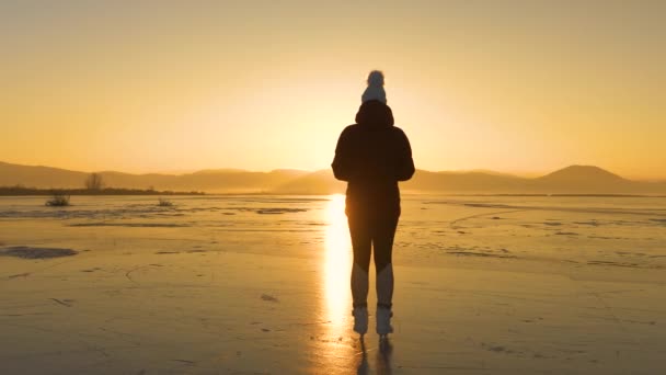 Lens Flare Silhouette Ice Skater Stands Frozen Lake Admires Setting — Stock Video