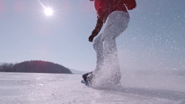 スーパーSlow Motion Close 若い男がブレーキをかけ 飛ぶ氷でスプレーするのに適しています 大きな凍った湖で氷のスケートをしている間 彼はホッケーを止める練習をしている 冬のスポーツ活動のための美しい晴れた日 — ストック動画
