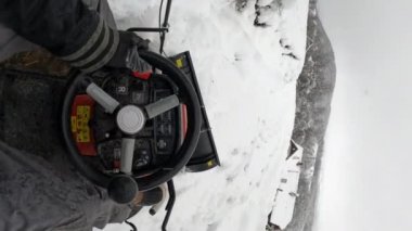 Karlı garaj yolunu temizlemek için küçük kar temizleme aracı ile taze kar yığınları sürüyorum. Yoldaki yoğun kar örtüsünü kaldırmak için kullanışlı bir makine. Kar yağdıktan sonra kırsal kesimde kış işleri