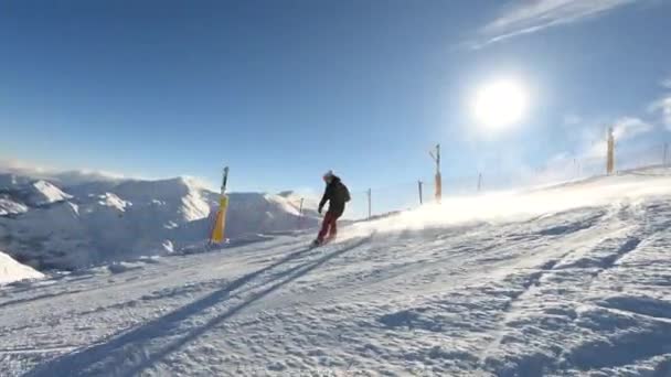 雪の高いアルペンスキーリゾートの絵の斜面を彫った女性スノーボーダー 彼女は白い山の美しい晴れた冬の日に新鮮な雪と成長したスキーガーデンでスノーボードを楽しんでいます — ストック動画