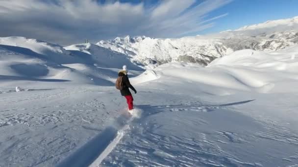 ジュリアンアルプスの新鮮な粉雪の上にスノーボードを解放するアドベンチュラスの女性 女性は手つかずの雪のターンを楽しむためにスキー場をオフにしました スノーボードに乗るための美しい晴れた冬の日 — ストック動画