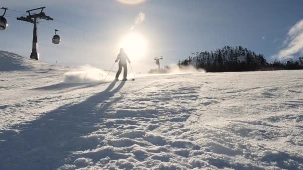 Lens Flare Low Motion Lady Sprays Snow Camera While Ski — 图库视频影像
