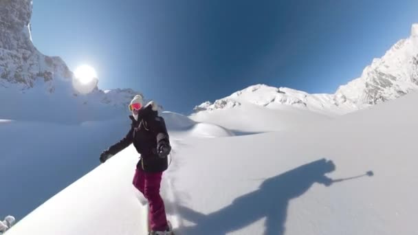 Selfie Lens Flare 幸せな女性は 美しいアルバニアアルプスでの冒険ヘルボード旅行で手つかずの雪の地形をスノーボードを楽しんでいます 彼女は新鮮な粉雪の乗馬と噴霧雲を持っています — ストック動画