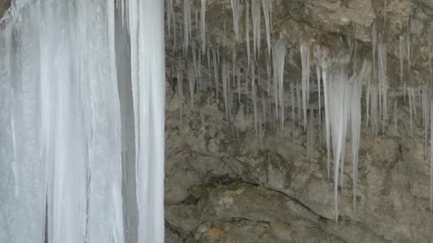 巨大的冰柱挂在一个狭窄的莫斯特尼察峡谷的悬垂上 冰冻的流水形成了美丽的冰层 寒冷的冬季大自然的奇妙创造物 — 图库视频影像