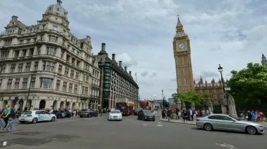 LONDRA, BİRLİK KINGDOM, 15 Eylül 2023: zaman LAPSE: İngiliz başkentinde caddenin üzerinde yükselen muhteşem saat kulesi. Kalabalık insanlar ve araçlar meşhur Big Ben 'in kavşağından geçiyor.