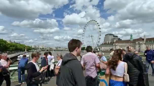 ロンドン ユニテッドキングダム September 2023 タイムラプス ロンドンアイの美しい景色を望むウェストミンスター橋の歩行者の群衆 浮遊する観光船とテムズ川を渡る橋 — ストック動画