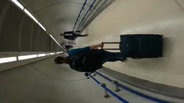 Londra, BİRLİK KINGDOM, 15 EYLÜL 2023: HYPERLAPSE: dolu bir metro istasyonundaki koridorda yürüyen kadın. Kadın yolcu Londra 'daki bir sonraki aktarmalı trene yetişmek için acele ediyor..