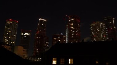 Parlayan pencere ışıkları olan uzun ve modern gökdelenlerin gece görüşü. Gece geç saatlerde Londra 'nın iş ve konut binalarıyla güzel şehir manzarası.