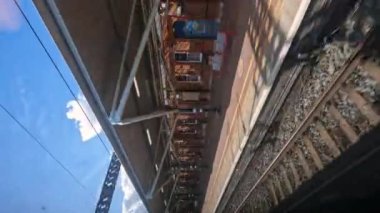 BATI MIDLANDS, BİRLİK KINGDOM, 15 Eylül 2023: POV VERTICAL: Gelen bir yolcu treni geldiğinde istasyondan tren yolculuğu. Paralel demiryolu hatları olan demiryolu tesisleri ve altyapısı.