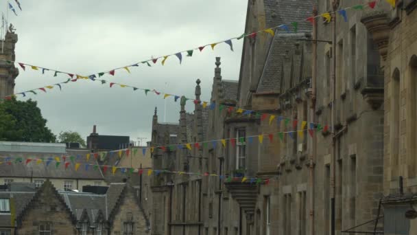 五彩缤纷的彩旗挂在美丽的中世纪城镇房屋之间 用彩旗装饰的历史建筑的风景如画的石墙 古城旧城区的节日气氛 — 图库视频影像