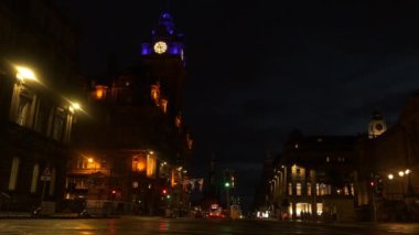 Tarihi Edinburgh şehrindeki eski binaların turuncu ve mavi cepheleri. Turist kasabasındaki tarihi binalar hakkında güzel aydınlatılmış mimari detaylar. İskoçya başkentinde akşam yürüyüşü.
