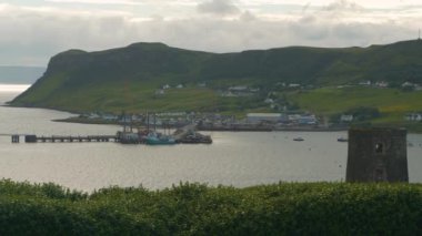Skye Adası 'nda iskelesi ve demirlemiş balıkçı tekneleri olan pitoresk bir liman köyü. Tipik İskoç yeşil çimenli kıyı manzarasına yayılmış birkaç evle huzurlu bir ada limanı manzarası.