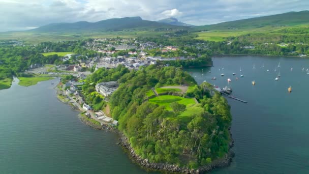 Aerial 在阳光灿烂的日子里 美丽的海滨小镇 斯凯岛上有港口 迷人的波特丽在一个多山的绿色岛屿的海岸的一个隐蔽的部分 苏格兰北部美丽的风景 — 图库视频影像