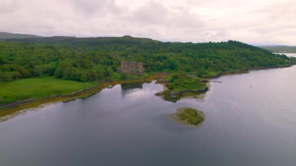 エリアル 中世ダンビーガン城は 海底を見下ろす高架岩の上に建てられました 美しい緑のスコットランドの田園地帯の海岸に美しい歴史的建造物 スカイ島の素晴らしい景色 — ストック動画