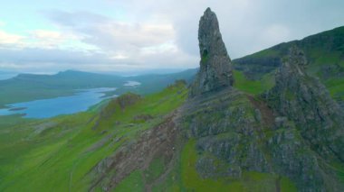 Göllerin üzerinde ve Skye Adası 'ndaki yeşil vadide resimli kaya oluşumları. Storr 'un Yaşlı Adamı' nın çimenli Trotternish Tepesi 'nin kenarında nefes kesici manzarası, İskoçya' nın ünlü doğal cazibesi..