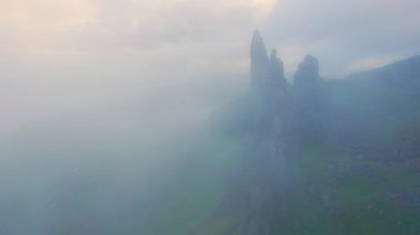 Storr 'un Gizemli İhtiyar' ı dağı örten sisin içinden bakıyor. Çimenli Trotternish Sırtı 'nın kenarındaki ikonik bir simgenin dramatik manzarası, İskoçya' nın ünlü doğal cazibesi..