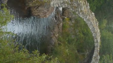 Eski kemerli Tabut Köprüsü Dulnain Nehri 'nin kayalık kıyılarını birbirine bağlıyor. Tarihi Carrbridge yük beygiri köprüsünü çevreleyen bereketli yeşillik. İskoçya 'nın İskoç İskoçya' sında turistik bir eğlence merkezi..
