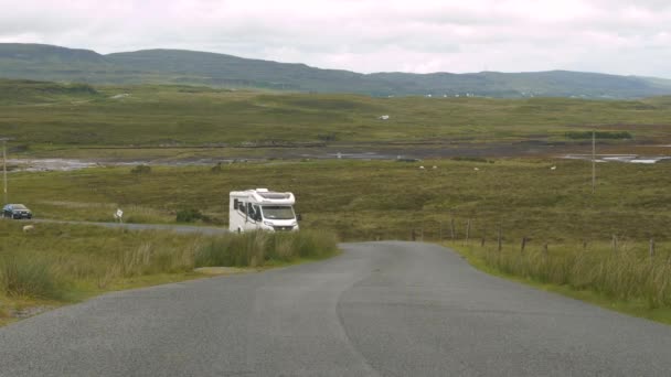 スカイプ スコットランド ユニトレッドキングダム 15September 2023 ホワイトツーリストのモーターホームは 緑の牧草地の間のアスファルト道路に沿ってドライブします 旅行者はスカイ島を横断するロードトリップです — ストック動画