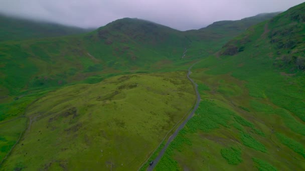 Aerial Uma Estrada Asfalto Sinuosa Entre Pastagens Montanha Verdes Lake — Vídeo de Stock