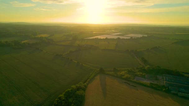 Aerial Lens Flare 飞向美丽的英国乡村上空升起的太阳 美丽的晨光洒在坎特伯雷郊外广阔的农田和绿地上 — 图库视频影像