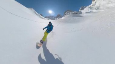 Erkek bölme tahtasının el değmemiş karlı dağda oyma işi var. Sıradışı bir snowboardcuyla yüksek dağlık bir dünyada inanılmaz bir manzara. Taze toz kar üzerinde her turun tadını çıkarıyor..