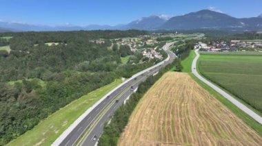 Taşra otoyollarını dolduran yolcuların ve turistlerin insansız hava aracı bakış açısı. Kırsal çevre yolu boyunca çok sayıda araba güneşli ülkeyi geçer. Yeşil Slovenya 'da yoğun trafik.