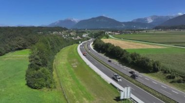Slovenya 'nın kırsal kesimlerinde yoğun trafik var. Taşra otoyollarını dolduran yolcuların ve turistlerin insansız hava aracı bakış açısı. Sayısız araba güneşli kırsal bölgeyi otoyol boyunca sürer..