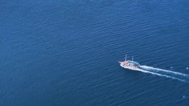 Sonsuz mavi denizde yelken açarken tek bir tekne beyaz bir uyanış yaratır. Hırvatistan 'ın sakin Adriyatik Denizi' nde yelken açan bir yatın manzarası. Güneşli bir yaz gününde deniz yolculuğu.