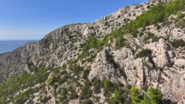 Hvar adasının muhteşem kireçtaşı kayalıkları Adriyatik Denizi 'ne bakıyor. Güneşli bir yaz gününde Akdeniz 'deki engebeli adaların nefes kesici manzarası. Hırvat sahil manzarası panoramik