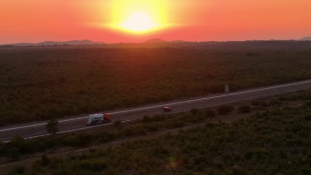 Aerial Pomarańczowe Wieczorne Promienie Słońca Oświetlają Ciężarówkę Ładunkiem Jadącą Przez — Wideo stockowe